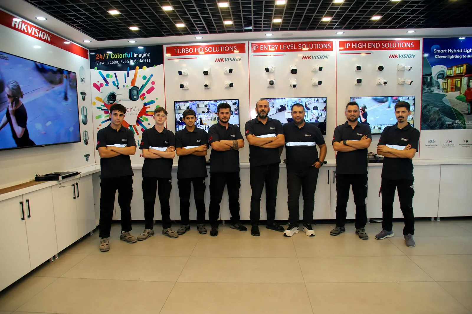 Telmag ekibi Akhisar showroomunda, kamera duvarının önünde toplu halde